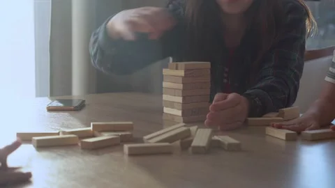 Small Kids Children playing tiny jenga with her parents at table, jenga tower Stock Footage 172552922