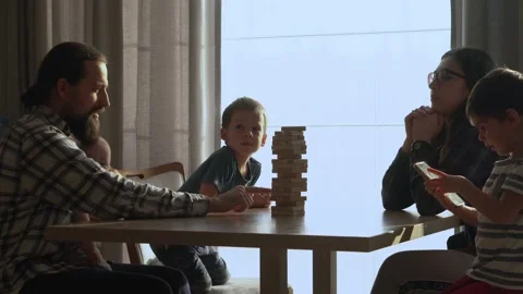 Small Kids Children playing tiny jenga with her parents at table, jenga tower Video stock 172756029