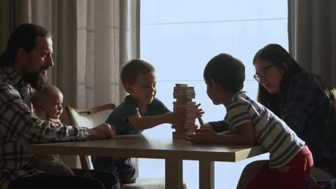 Small Kids Children playing tiny jenga with her parents at table, jenga tower Video stock 172756542