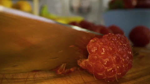 Small knife cutting through tiny raspberry - extreme closeup shot Stock Footage 341192019