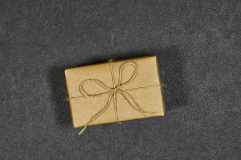 Small Kraft Gift Box Wrapped With Twine Ribbon On Dark Slate Background for Gift Stock Photos
