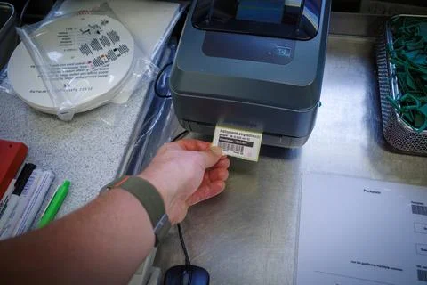 A small label is pulled out of a label printer Stock Photos