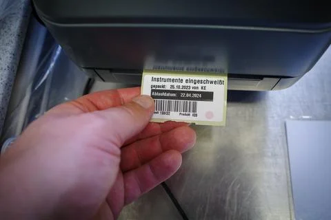 A small label is pulled out of a label printer Stock Photos