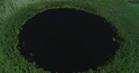 Small lake of perfectly round shape. 4K Stock Footage 156500590
