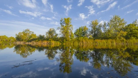 Small lake under a cloudy sky,  4K time lapse scene Video stock 117241514