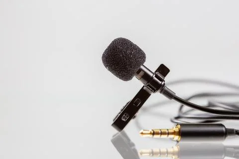 Small lavalier microphone or lapel mic with clip on white background. Stock Photos
