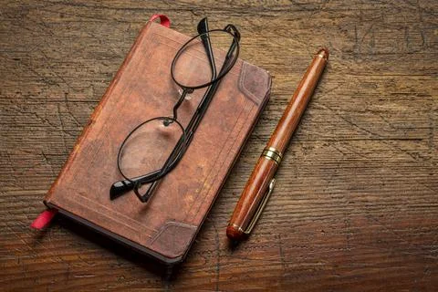 Small leather-bound journal on rustic wood Stock Photos