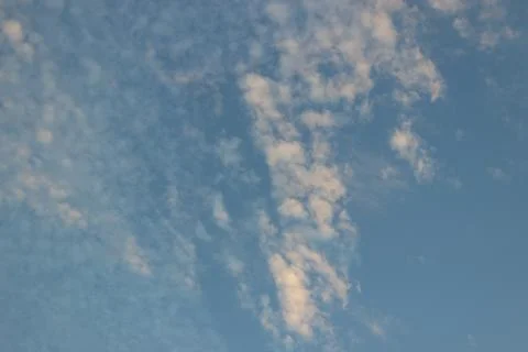 Small, light and warm clouds spread out over sky Stock Photos