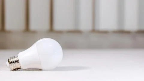 Small Light Bulb on White Table Stock Photos