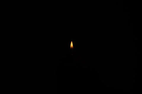 Small lighter flame isolated on dark black background, no people 스톡 사진