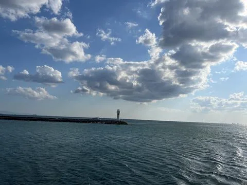 Small Lighthouse on Breakwater Under Dramatic Clouds Stock Photos