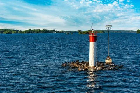 Small lighthouse on the river under blue skies with fluffy cloud Stock Photos