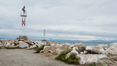 Small lighthouse on a rocky beach and calm sea water Stock-Footage 117585332