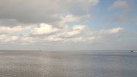 Small Lighthouse with a Small Motorboat Passing Stock Footage 125058411