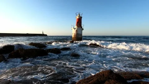 Small lighthouse surrounded by waves on rocky Cantabrian coast in San Vicen.. Stock Footage 343227511