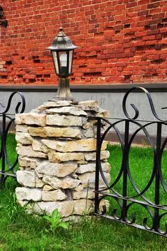 Small lighting lantern on a base of flat stones. Stock Photos