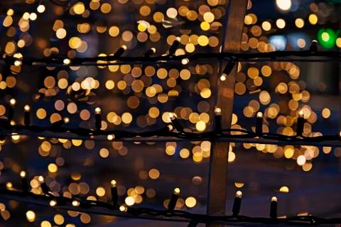 Small lights on long cords with lots of bokeh in the background Stock Photos