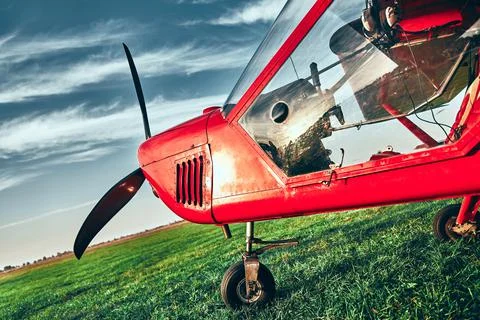 Small lightweight private airplane standing on airfield grass Stock Photos
