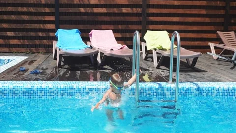 Small little boy jumping diving into swimming pool water. Little boy in the pool Stock Footage 121436789