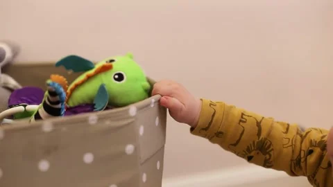 A small little crawled to the toy box and tries to get hold of your favorite toy Stock Footage 145414473