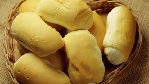 Small loaves of bread arranged in a rustic wicker basket on natural jute Stock-Footage 337210200