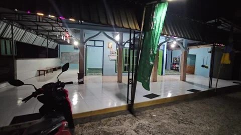 Small Local Mosque Or Prayer Room Exterior With Colorful Lights And Motorcycle Stock Footage 339829606