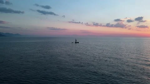 A small lonely lighthouse in the open sea, dawn drone flight, 4k Video stock 217728247