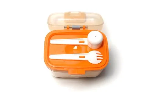 Small lunch box with plastic spoon and fork on top, isolated on white backg.. Stock Photos
