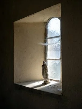 Small madonna statue in window sill of old french chapel Foto stock