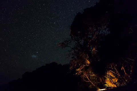 Small Magellanic Cloud or SMC is seen at night over wild campsite in by the sea 스톡 사진