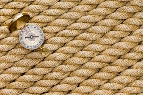 Small magnetic compass on diagonal strands of rope Stock Photos
