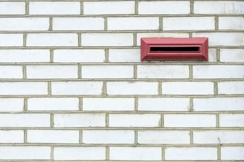 A small mailbox on a white brick wall Stock Photos