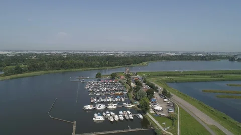 Small marina wit a sunny sky and a old Dutch traditional windmill located Stock Footage 113213042