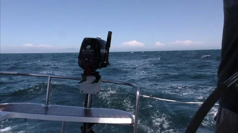 Small marine motor lashed to stern of sail boat at speen in open pacific ocea Video stock 67512766