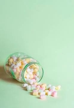 Small marshmallows in an overturned jar Stock Photos
