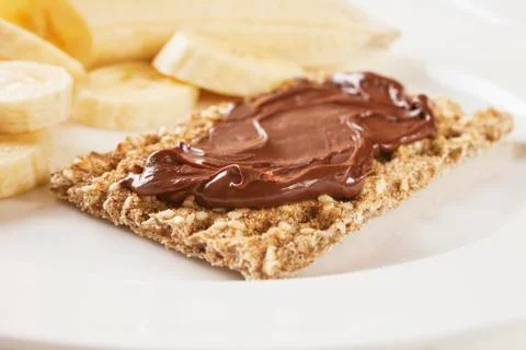 A small meal of crispbread with chocolate spread and a large banana, for a to Stock Photos