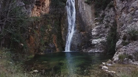 Small Mediterranean waterfall on rocky ground. Jib movement. Video stock 124862704
