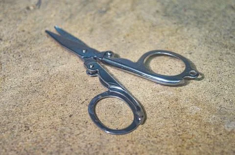 A small metal folding pair of scissors Stock Photos