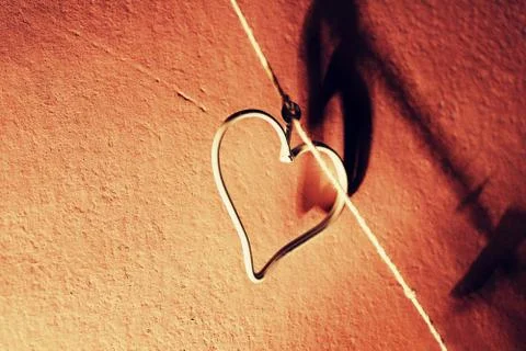 A small, metal heart on the string close up Stock Photos