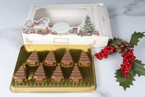 Small milk chocolate bars shaped like Christmas trees. Stock Photos