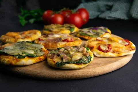 Small mini pizza. Set of different mini pizzas. Pizza on wooden board: with s Stock Photos