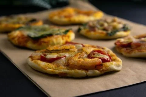 Small mini pizza. Set of different mini pizzas. Pizza on craft paper: with sh Stock Photos