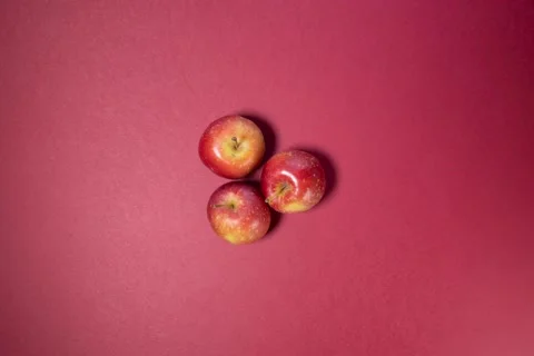 Small mini red cherry lady apple on red background stop motion  Stock Footage 132385428