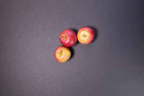 Small mini red cherry lady apple on  black background stop motion  Stock Footage 132385516