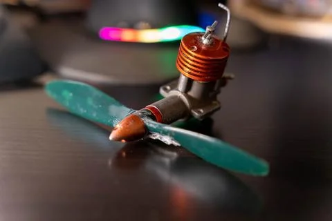 Small model engine with a propeller placed on a dark surface in a workshop .. Foto stock