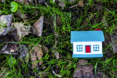 Small model of house over spring grass background. Stock Photos