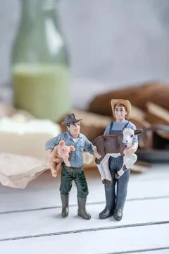Small models farmers with sliced bread with a milk and butter on a on natural Stock Photos