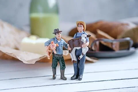Small models farmers with sliced bread with a milk and butter on a on natural Stock Photos