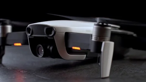 Small modern drone quadcopter over dark background with running engines Stock Footage 103430445