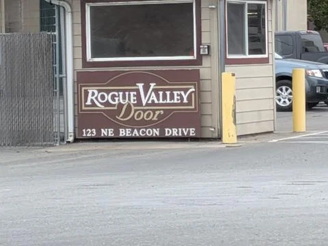 Small modern security building with tinted glass and “Rogue Valley Door” Stock Photos